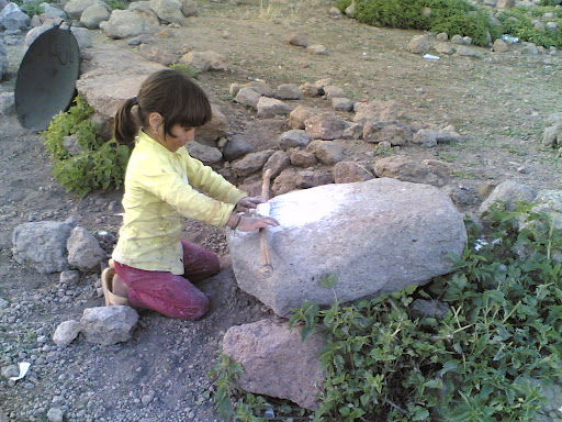 دخترکی که در ییلاق در حال پهن کردن خمیر به روی سنگ می باشد برای پخت نان - 870510- پرویز ستوده شایق 