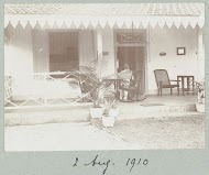 Man in een schommelstoel op de veranda van een woning.