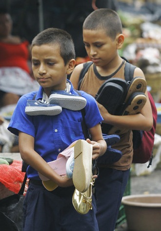 NIÑOS TRABAJADORES. Carlos Alberto, de 10, y su hermano José Manuel Rivera, de 12 años venden zapatos en La Tiendona. Afirman que un buen día venden hasta $12 dólares vendiendo unos seis pares de zapatos. Foto de La Prensa, Oscar Leiva