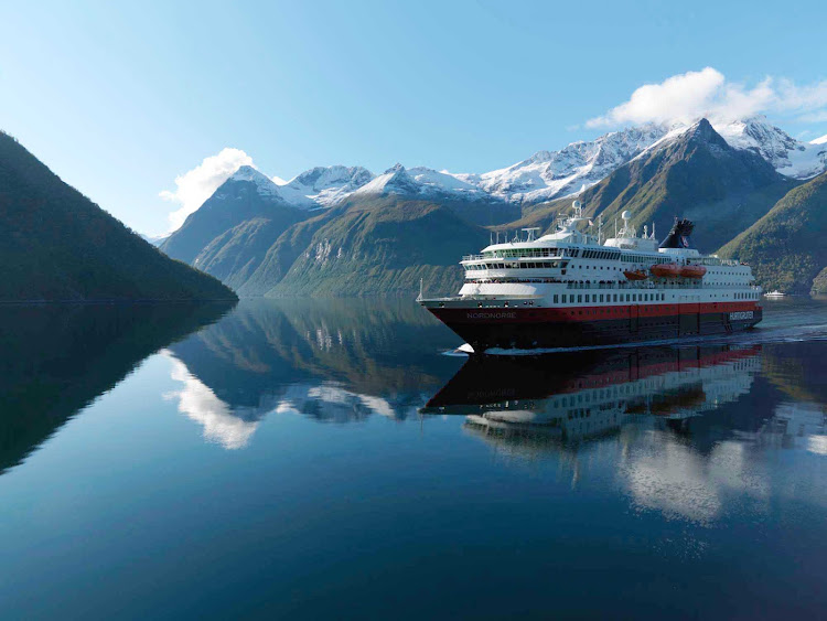 Surrounded by imposing mountains, Hurtigruten's Nordnorge travels along the Hjørundfjorden fjord in Norway. 